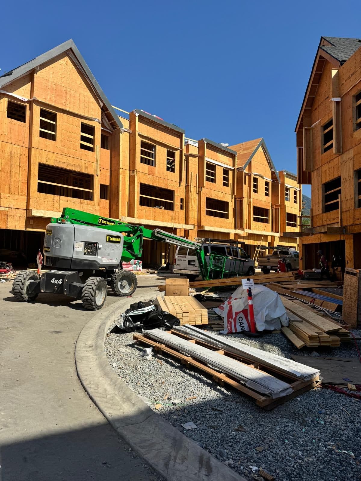 Townhouse framing in progress with a boom lift on site